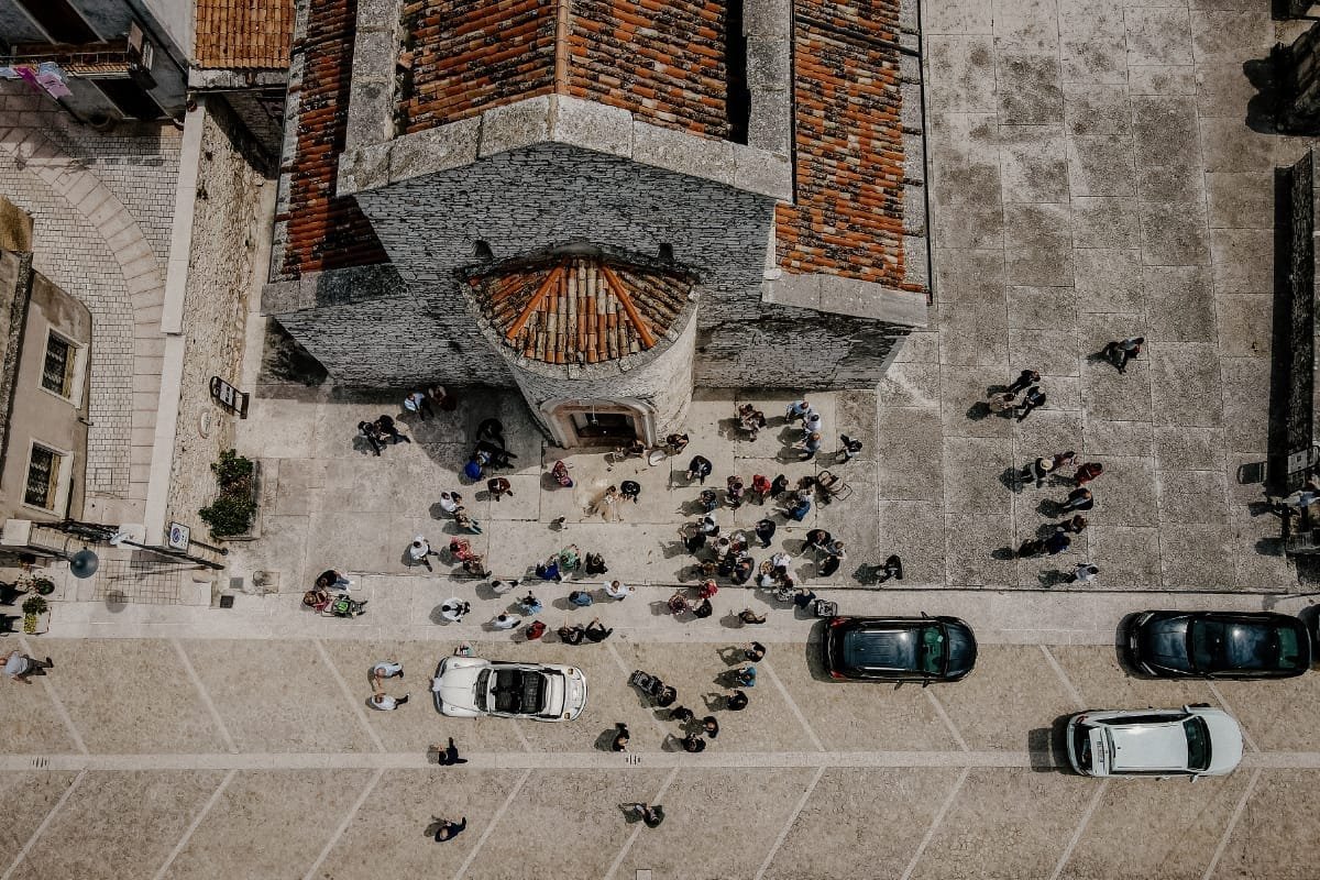Vista dall’alto degli invitati e delle auto davanti alla chiesa dopo la cerimonia