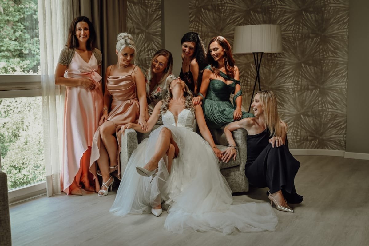 Sposa con le amiche in abito da cerimonia durante i preparativi