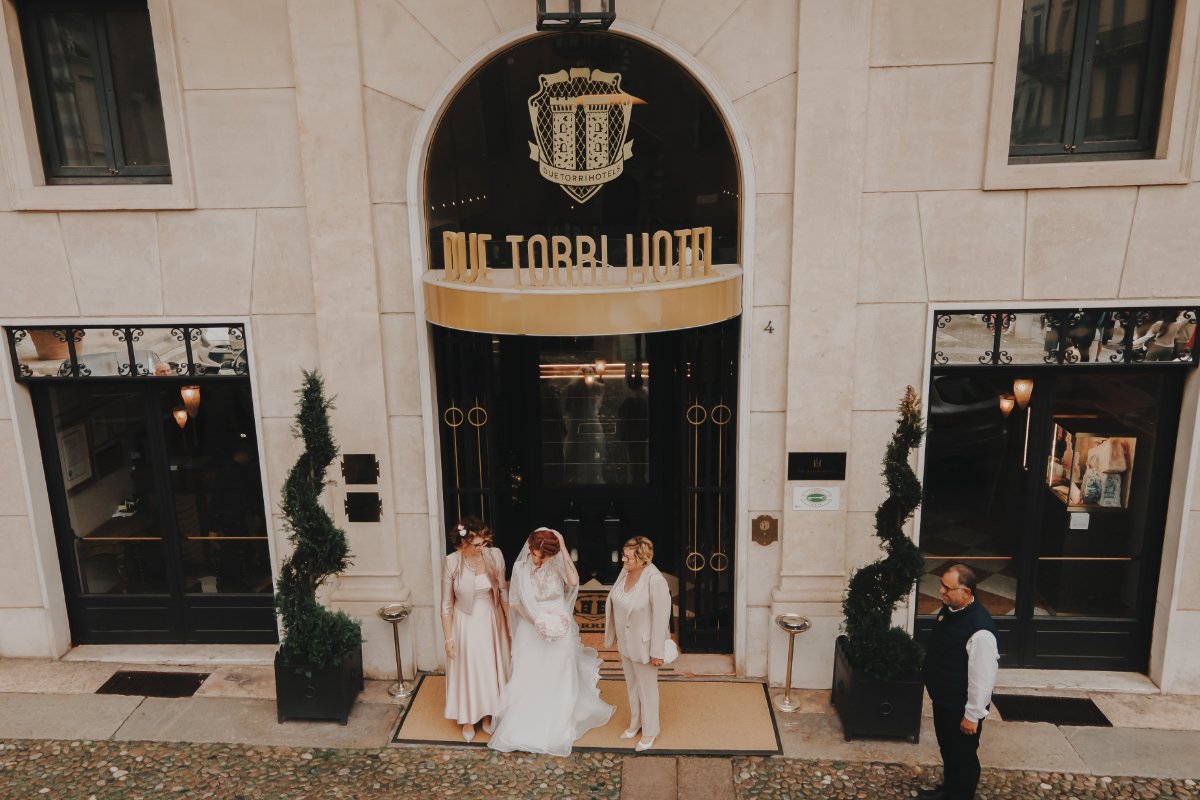 Sposa con le damigelle all’ingresso dell’Hotel Due Torri di Verona, foto di Camilla Lovato