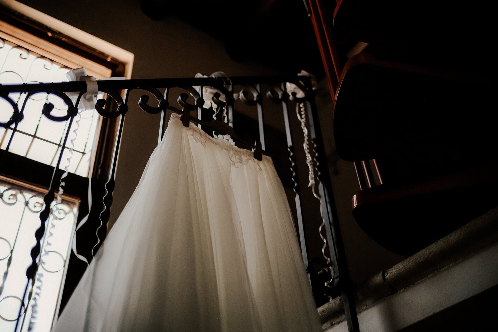 Abito da sposa appeso a una ringhiera in ferro battuto
