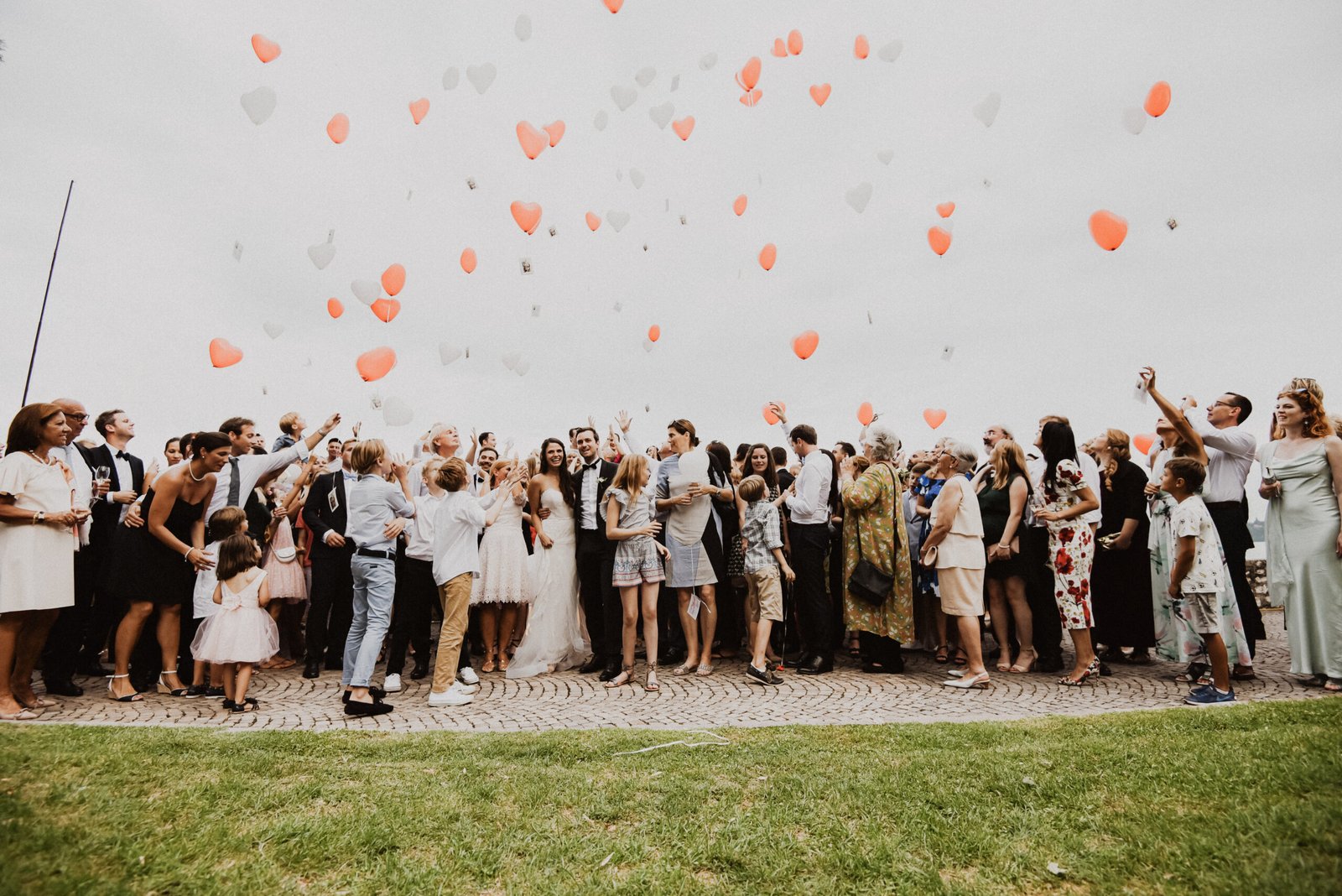 Invitati che liberano palloncini a forma di cuore verso il cielo